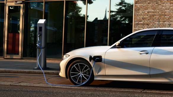 Visão lateral do veículo plug-in híbrido BMW Série 3 Sedan 2021 Visão lateral do veículo plug-in híbrido BMW Série 3 Sedan 2021 G20 na estação de carregamento