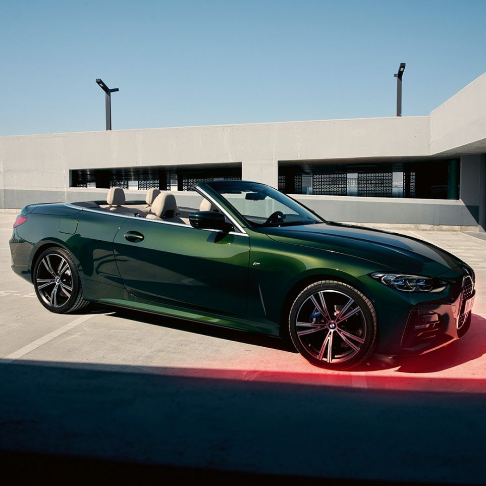 Vista frontal a três quartos do BMW Série 4 Cabrio, G23, 2020, com um homem BMW Série 4 Cabrio, G23, 2020, cor exterior verde Sanremo metalizada, vista frontal a três quartos com um homem ao lado