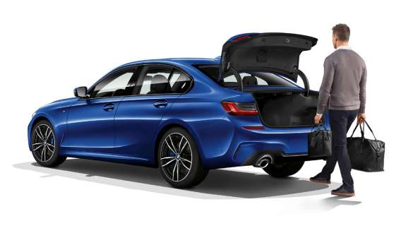 BMW Série 3 Sedã, operação automática da porta do bagageiro. Vista traseira a três quartos do BMW Série 3 Sedã parado com o motorista abrindo automaticamente a porta do bagageiro com o pé.