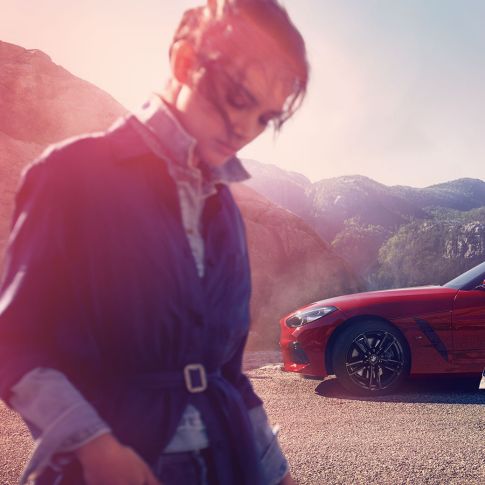 O BMW Z4 Roadster frente a uma vista de montanha Homem, mulher e o BMW Z4 Roadster frente a uma vista de montanha