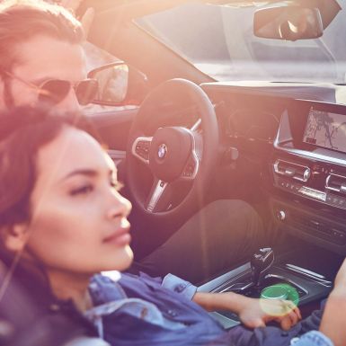 BMW Z4 Roadster com um homem e uma mulher Homem com mulher de cabelo escuro em um BMW Z4 Roadster