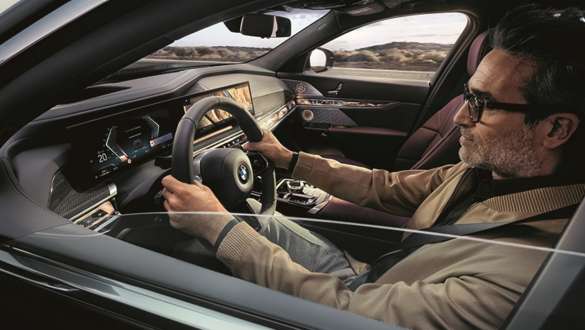 Um homem em um BMW, com as mãos ao volante de direção Um homem dirigindo um BMW, com as mãos ao volante de direção