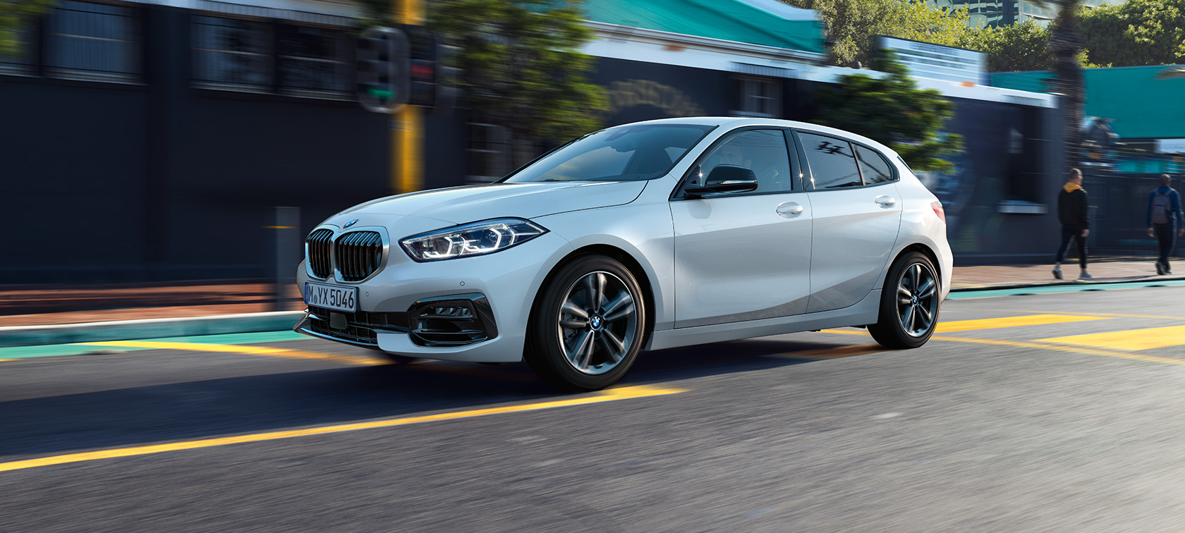 O BMW Série 1, Modelo Sport Line, vista lateral inclinada. O BMW Série 1, Modelo Sport Line na tonalidade Mineral White metálico, vista lateral inclinada, em movimento.