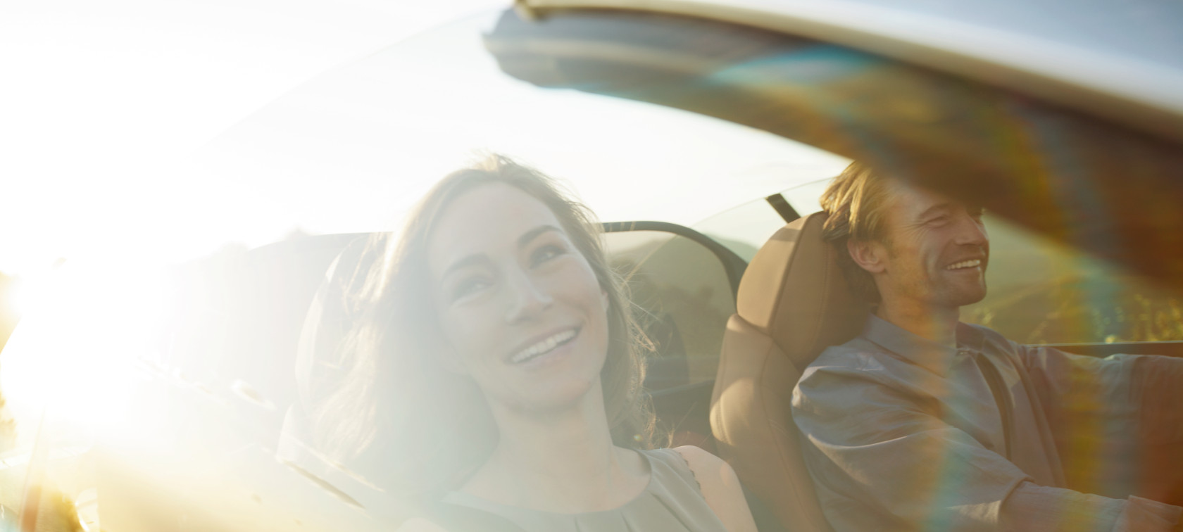 Casal sorrindo a bordo de um BMW Série 4 430i Cabrio com a capota aberta em um dia de sol Casal sorrindo a bordo de um BMW Série 4 430i Cabrio com a capota aberta em um dia de sol