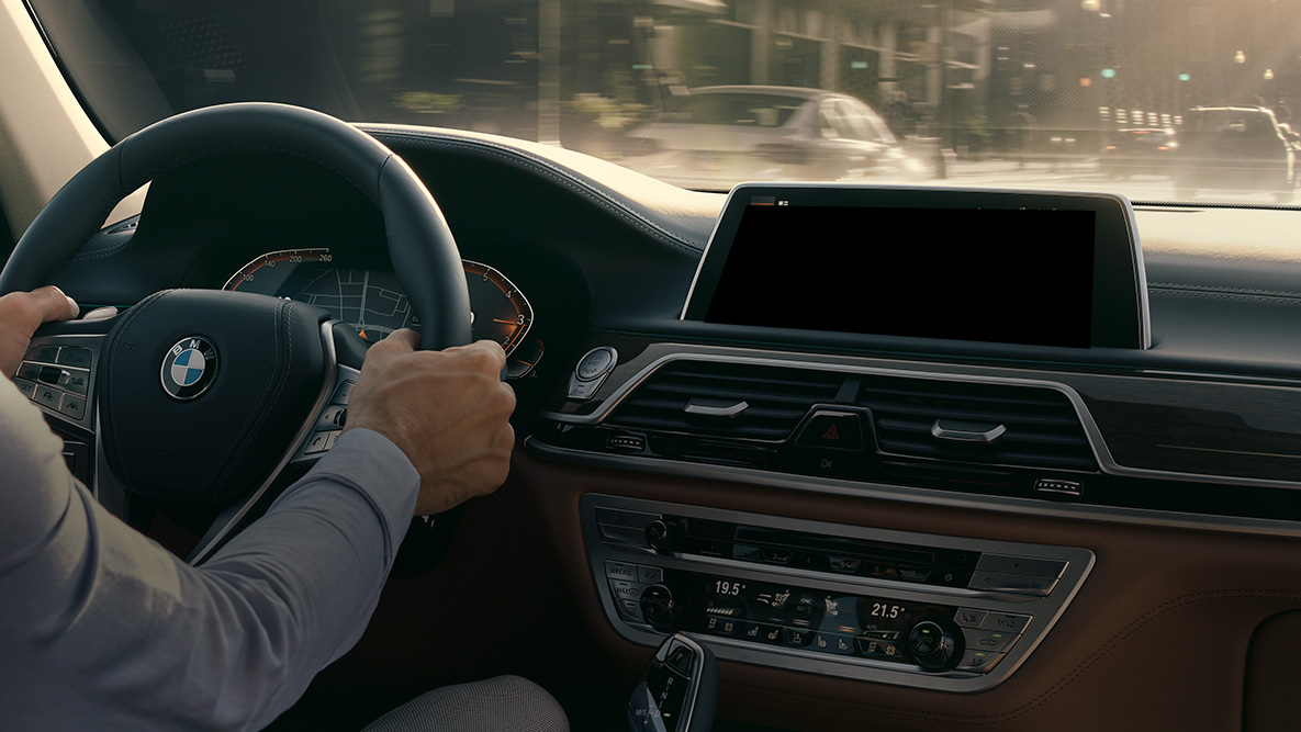 BMW Intelligent Personal Assistant O Assistente Pessoal Inteligente da BMW: foto de um homem dirigindo um BMW, closeup do Live Cockpit Professional