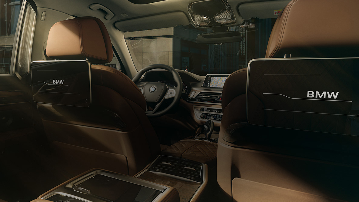 BMW Série 7 Sedan Entretenimento no banco traseiro BMW Série 7 Sedan: vista por detrás do banco traseiro mostrando as telas de toque HD do Entretenimento