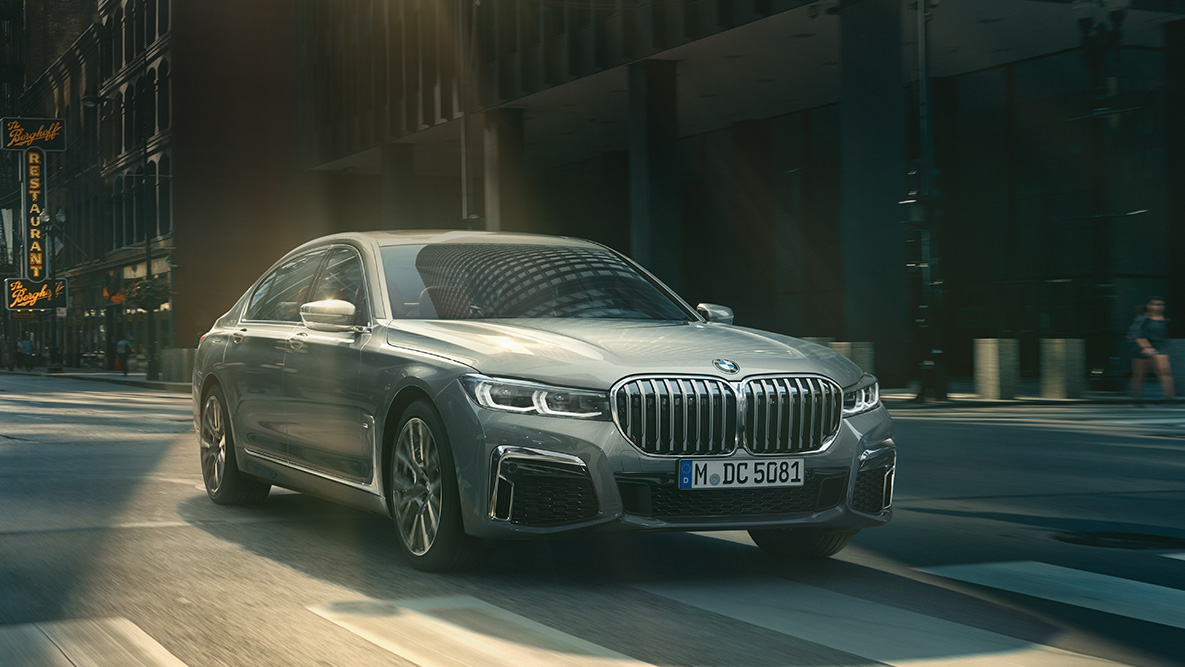 O Assistente de Direção Profissional do BMW Série 7 Sedan Assistente de Direção Profissional: vista frontal a 45 graus do BMW Série 7 Sedan movendo-se em frente a um cenário urbano