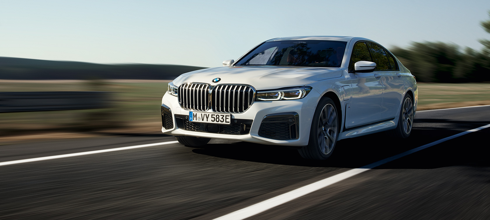 Vista frontal ¾ do modelo híbrido plug-in BMW Série 7 Sedan G11 G12, dirigindo Vista frontal 3/4 do modelo híbrido plug-in BMW Série 7 Sedan G11 G12, dirigindo em uma rua
