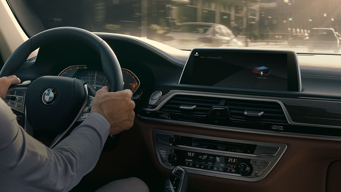 Intelligent Personal Assistant BMW O BMW Intelligent Personal Assistant: imagem de um homem dirigindo um BMW, close-up do Live Cockpit Professional