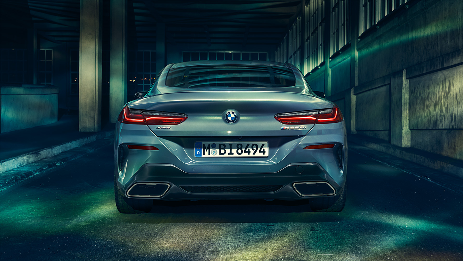 BMW Série 8 Coupé, vista traseira Vista traseira do BMW Série 8 Coupé à noite em um cenário urbano.