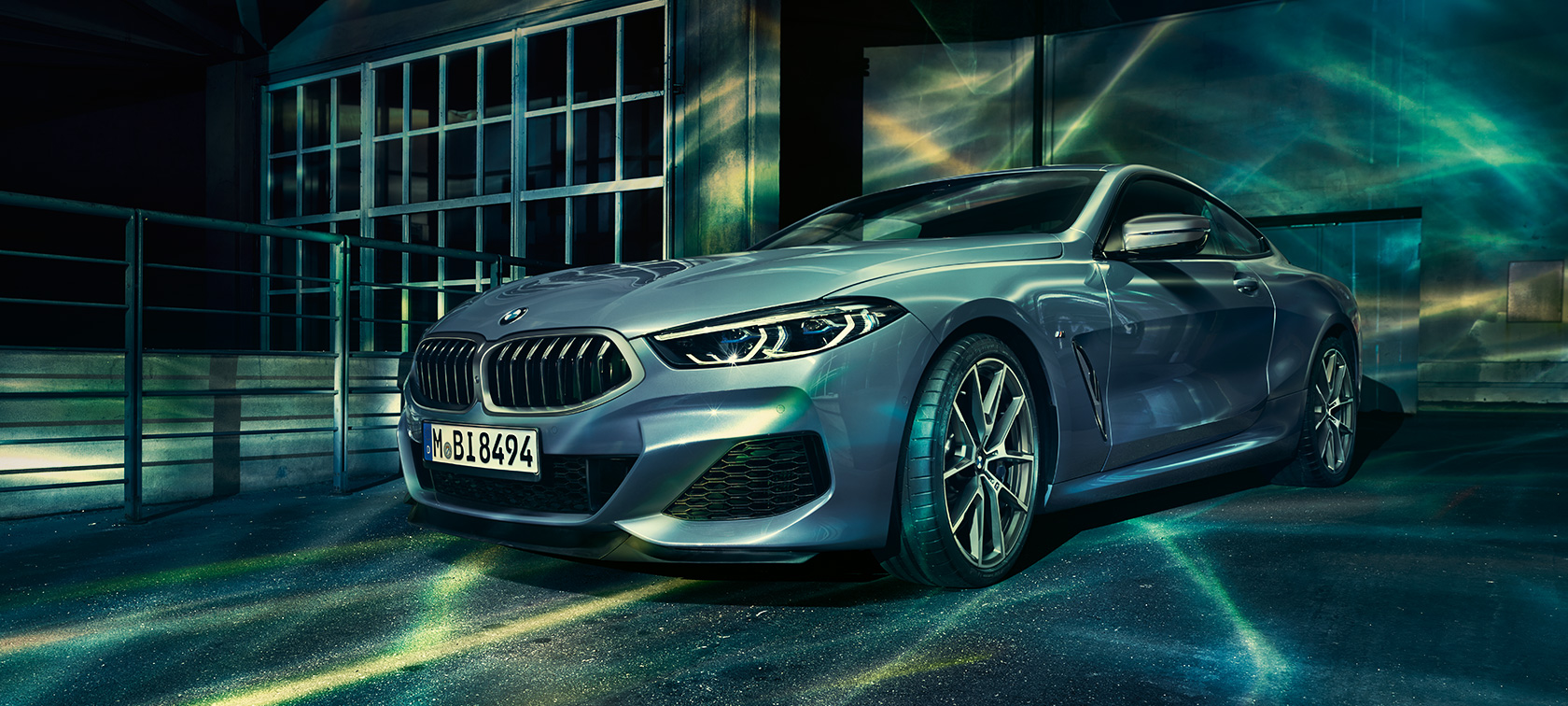 O BMW Série 8, imagem frontal a 45 graus. Uma imagem frontal a 45 graus, exibindo o BMW Série 8 Coupé em meio a uma paisagem urbana.