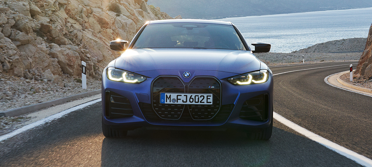Vista frontal do BMW i4 M50 G26 2021 Vista frontal do BMW i4 M50 G26 M na tonalidade Portimao Blue metálico, dirigindo na estrada