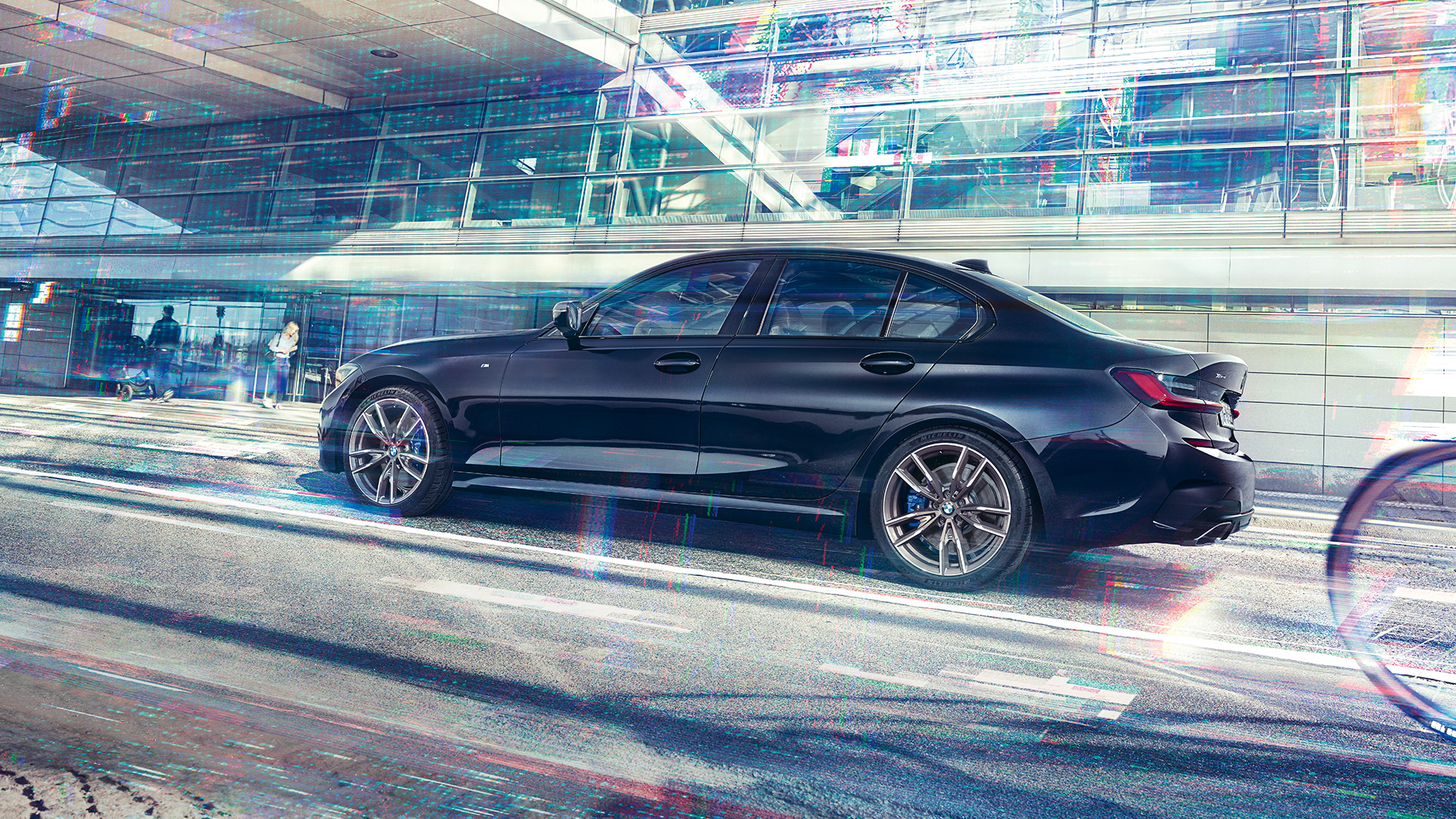 Visão lateral do BMW M340i xDrive Sedan BMW M340i xDrive Sedan G20 em preto safira metálico, visão lateral durante a condução do veículo