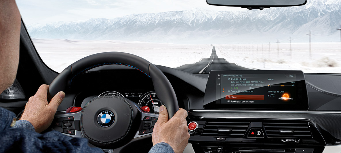 Vista interior do BMW M5 2020 Sedã com homem ao volante com uma longa reta de asfalto à frente Vista interior do BMW M5 2020 Sedã com homem ao volante com uma longa reta de asfalto à frente