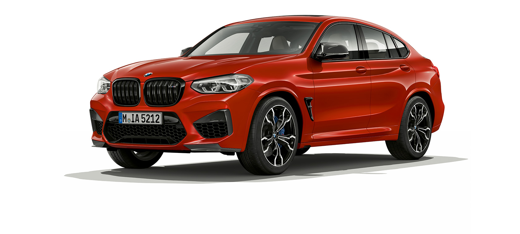 BMW X4 M Competition, visão lateral de três quartos. BMW X4 M Competition em vermelho metálico Toronto, exterior, visão lateral de três quartos.