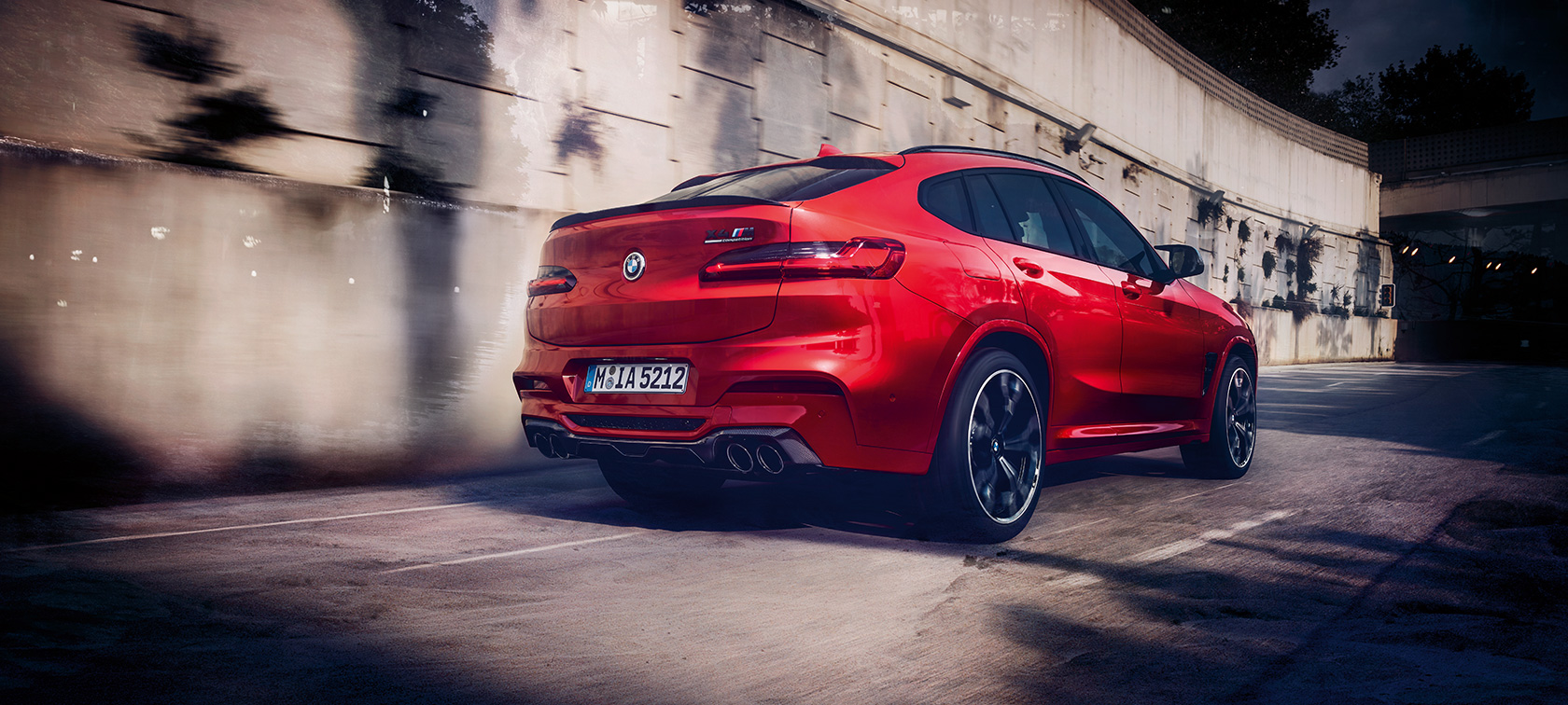 BMW X4 M Competition, visão traseira de três quartos. BMW X4 M Competition em vermelho metálico Toronto, direção, exterior, visão traseira de três quartos.
