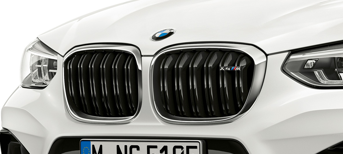 BMW X4 M, grade M. BMW X4 M em branco alpino, exterior, parte frontal, grade M com detalhes cromados e designação do modelo.