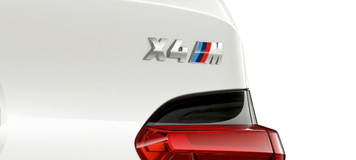 BMW X4 M, designação do modelo. BMW X4 M em branco alpino, exterior, visão ampliada da parte traseira com a designação do modelo.