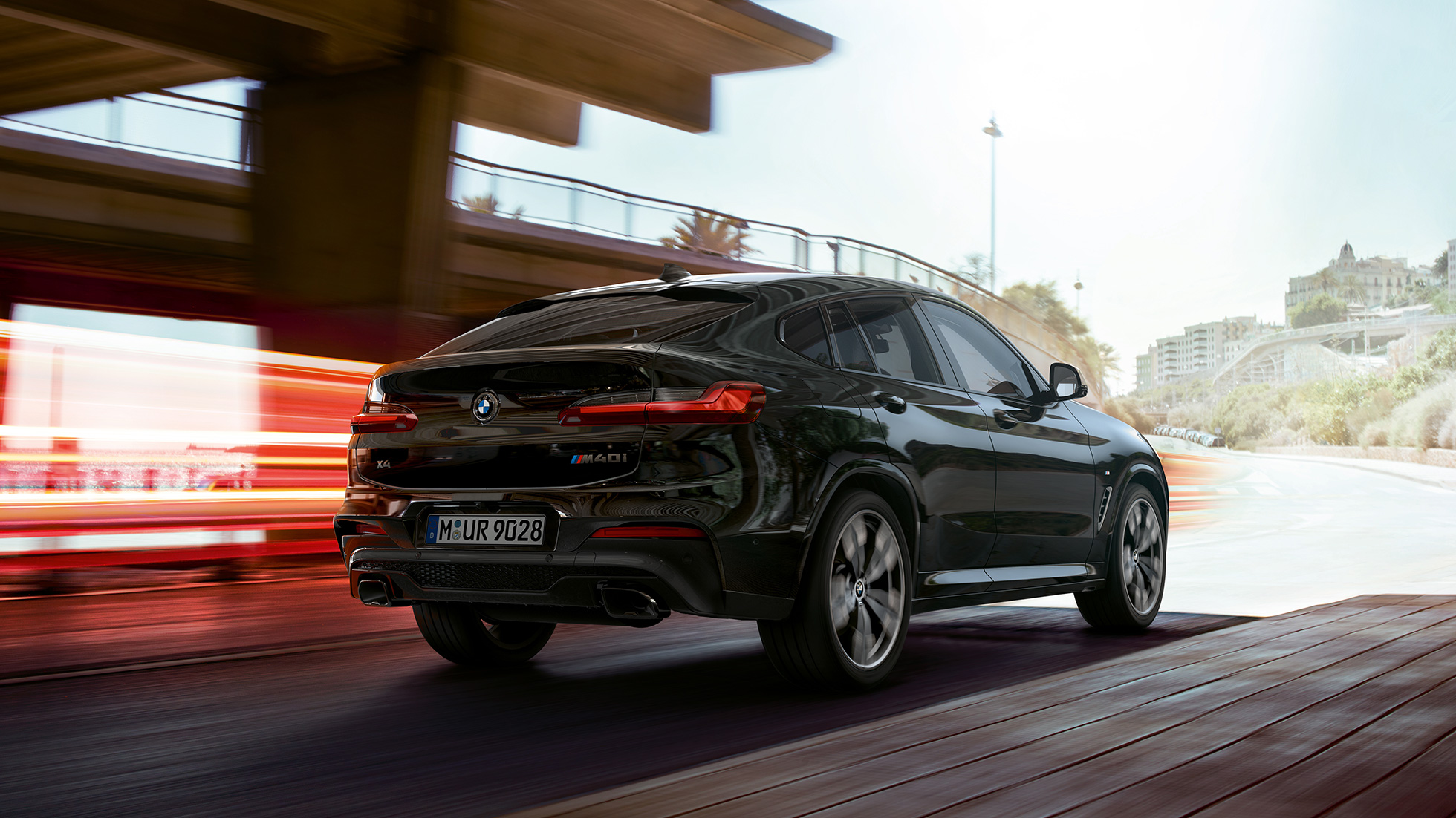 BMW X4 M40i, visão frontal de três quartos. BMW X4 M40i em preto safira metálico, direção, exterior, visão frontal de três quartos com tiras de luz.