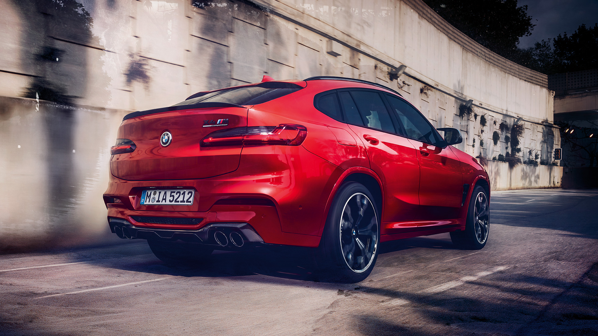 BMW X4 M Competition, visão traseira lateral. BMW X4 M Competition em vermelho metálico Toronto, exterior, visão traseira lateral.