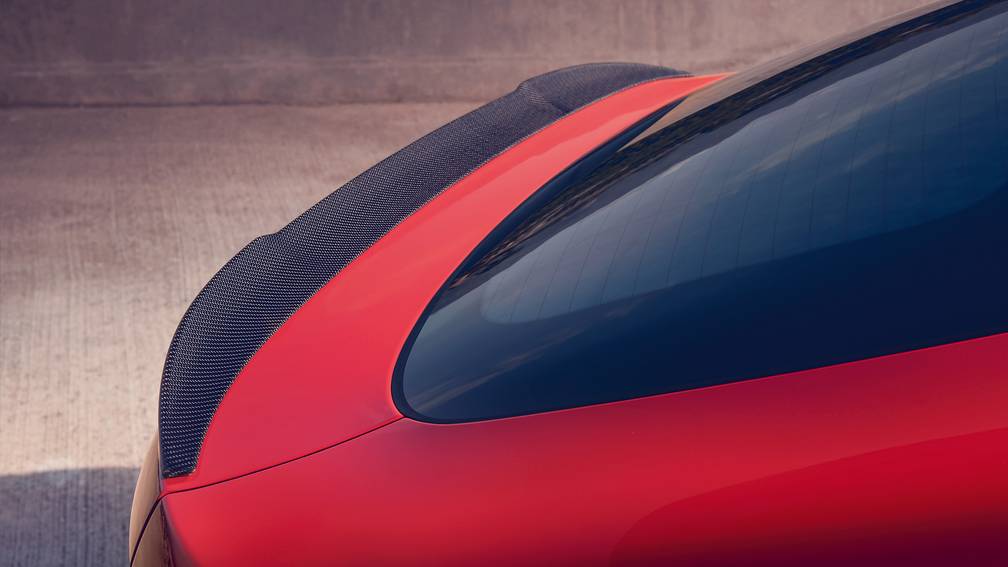BMW X4 M Competition, spoiler traseiro M em carbono. BMW X4 M Competition em vermelho metálico Toronto, exterior, pacote externo de M Carbon, visão traseira detalhada com spoiler traseiro M em carbono.