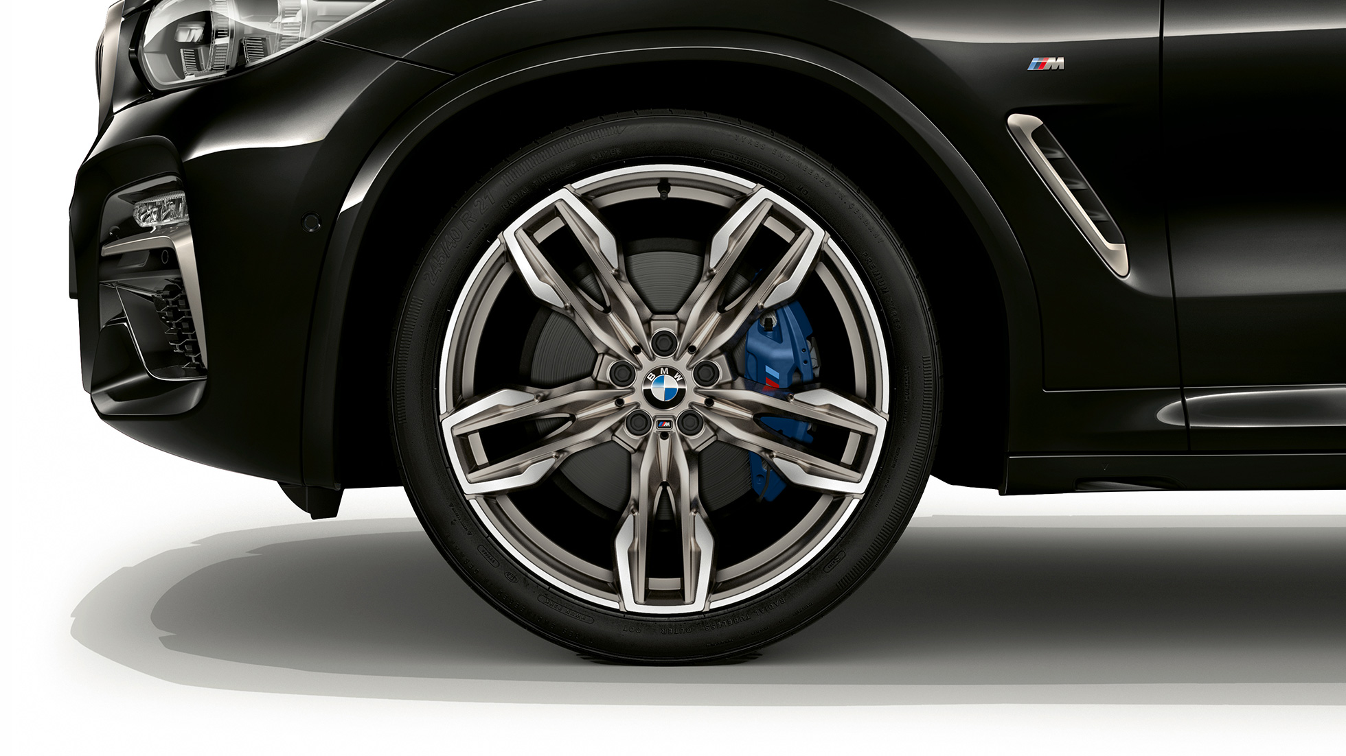 BMW X4 M40i e BMW X4 M40d, rodas de liga leve M de 21 pol. com design de raio duplo. BMW X4 M40i e BMW X4 M40d em preto safira metálico, exterior, visão lateral com rodas de liga leve M de 21 pol. com design de raio duplo.