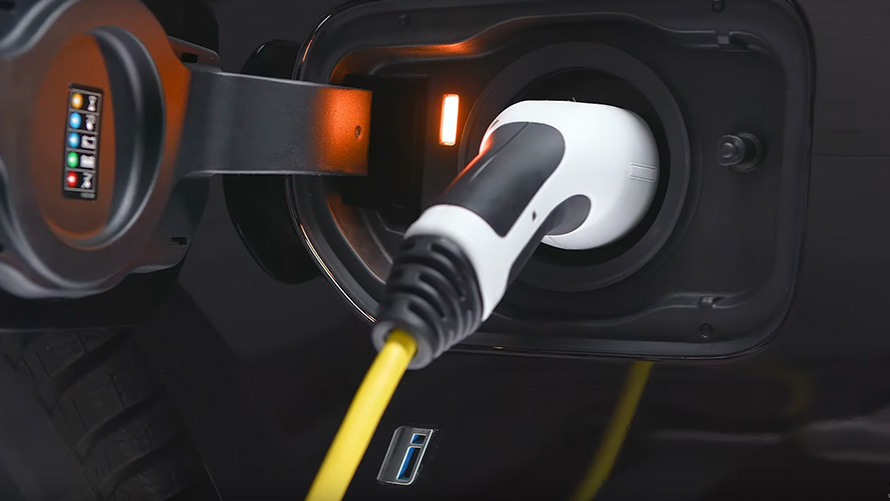 O BMW híbrido recarregável, conectado por meio de um cabo para recarregamento Vista em close-up do BMW X5 G05 híbrido recarregável, conectado por meio de um cabo para o recarregamento