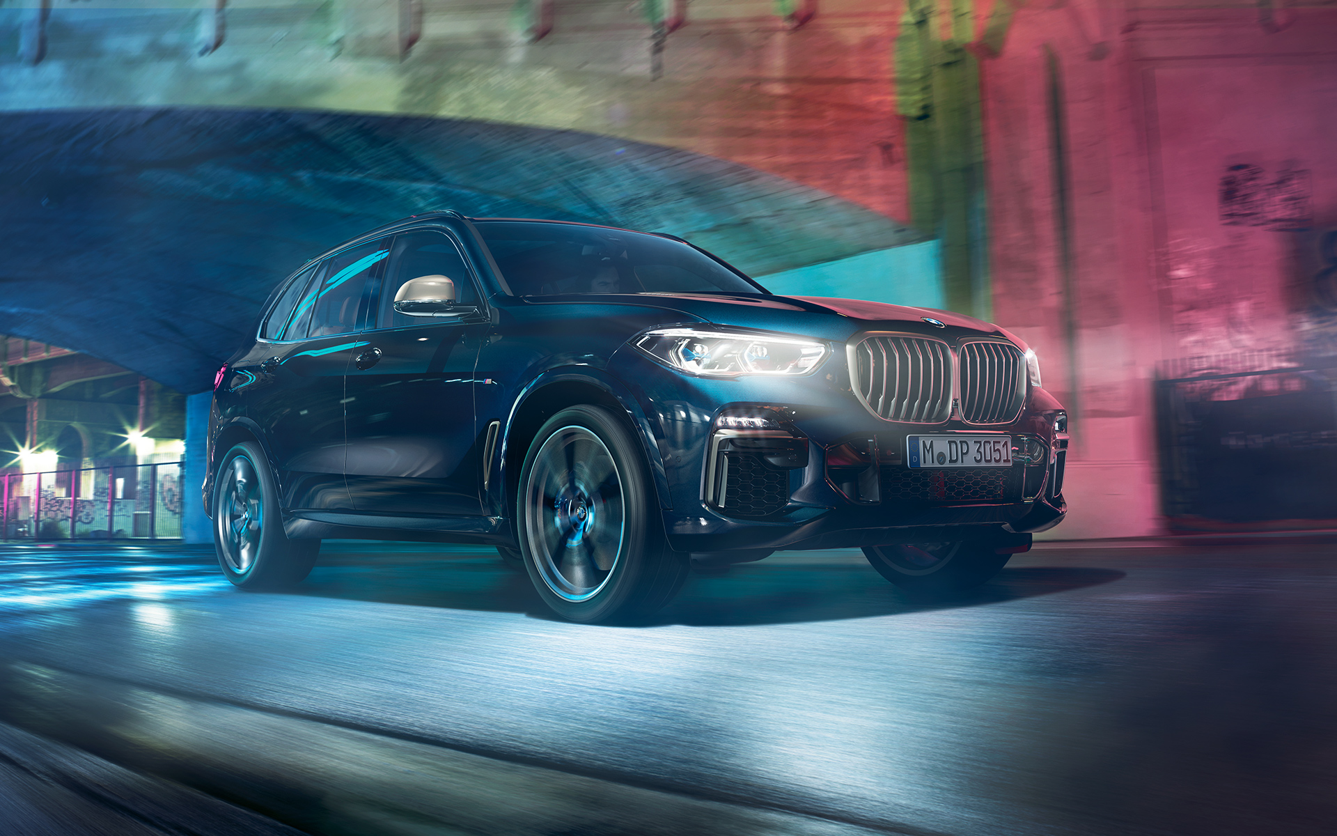 BMW X5 M50d em ação Foto do BMW X5 M50d à noite em um ambiente urbano