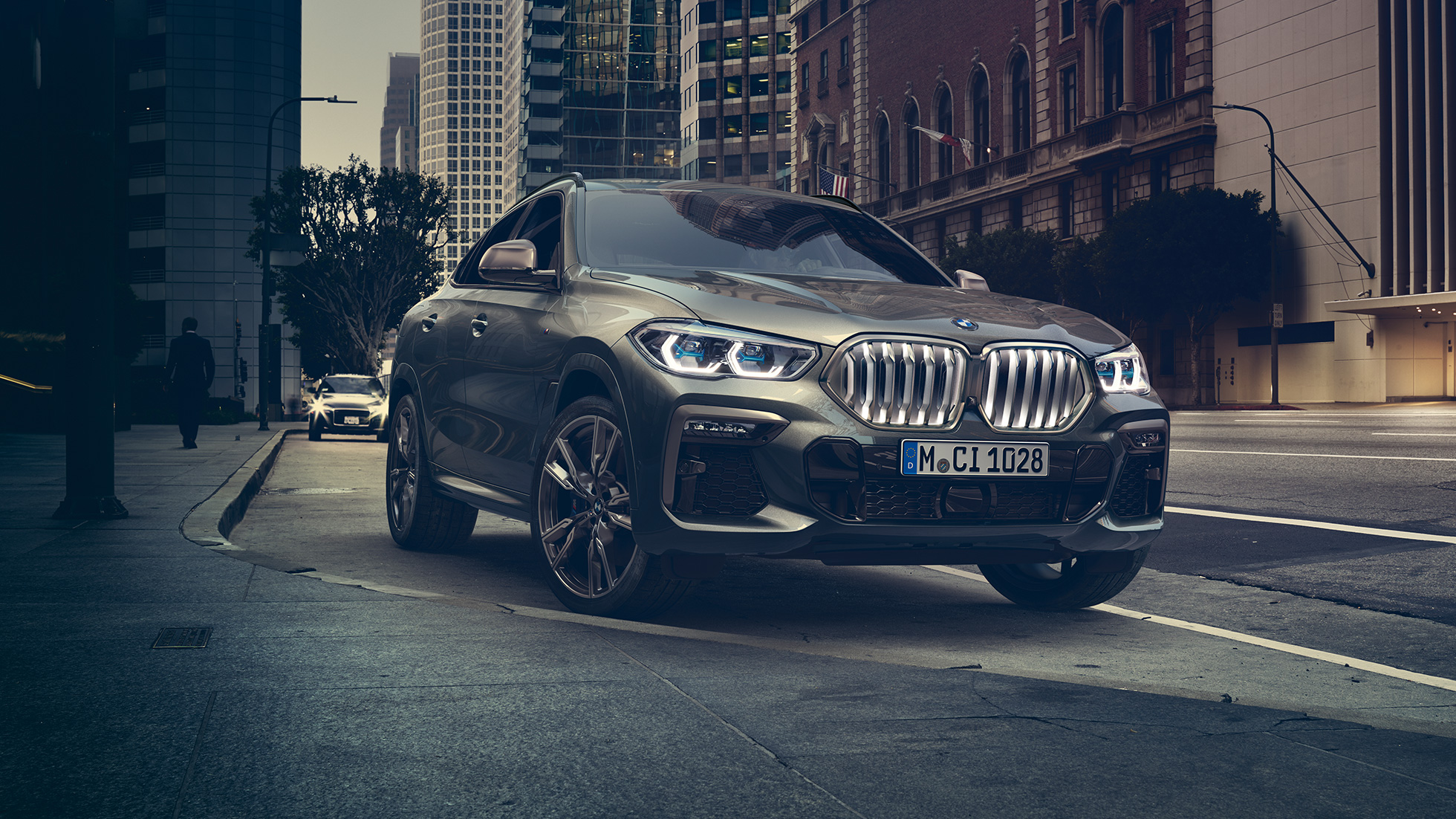 Suspensão Profissional Adaptável M do BMW X6 BMW X6 in three-quarter front perspective in front of an urban setting.