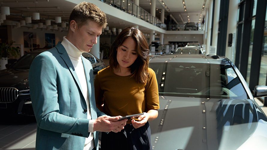 Um funcionário BMW orienta um cliente.