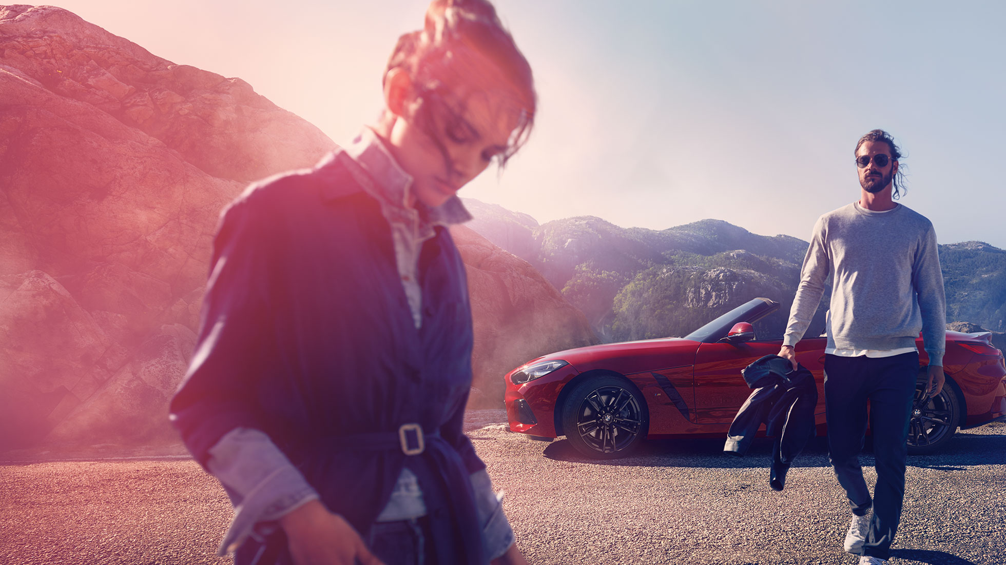 O BMW Z4 Roadster frente a uma vista de montanha Homem, mulher e o BMW Z4 Roadster frente a uma vista de montanha