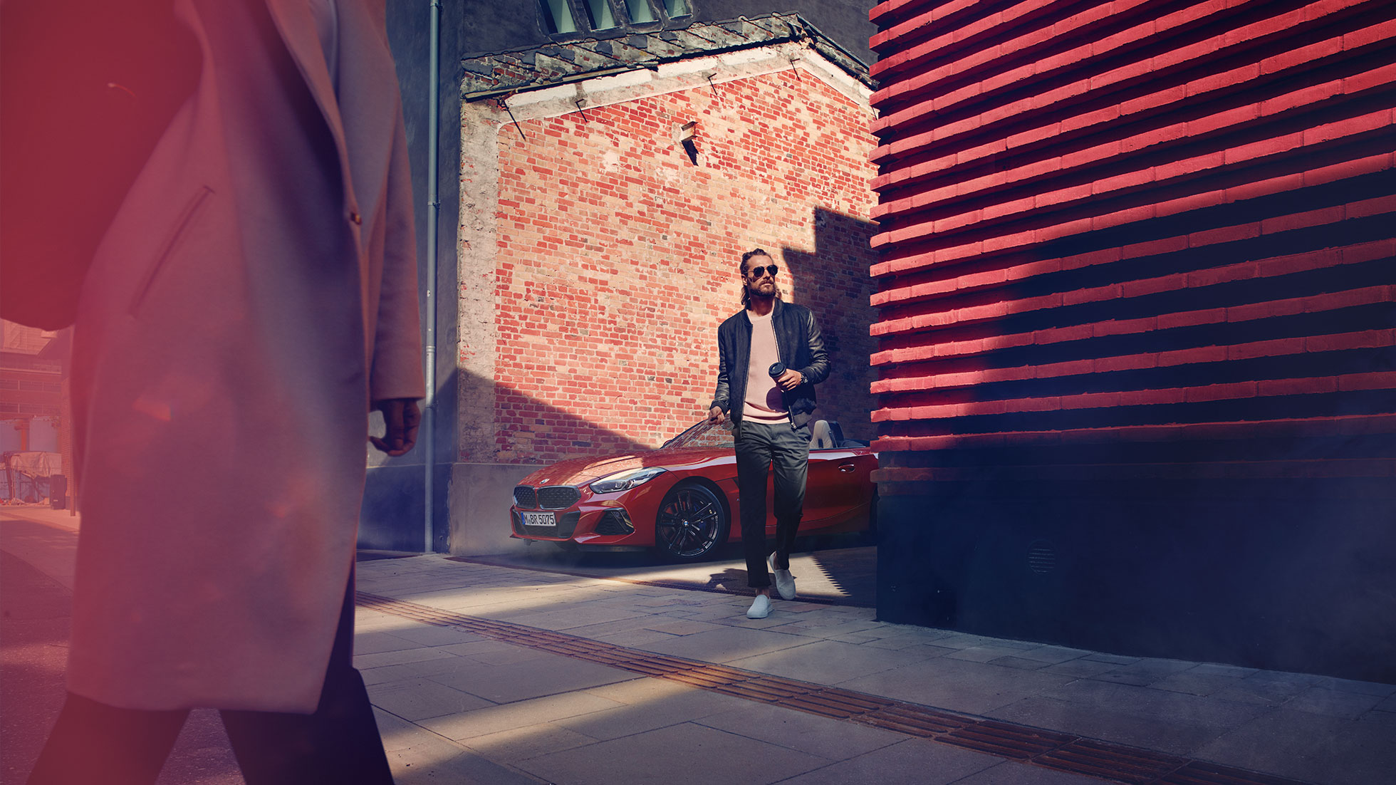 O BMW Z4 Roadster numa rua lateral Homem em uma rua lateral à frente do BMW Z4 Roadster