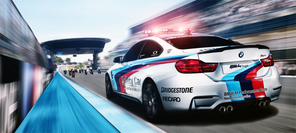 BMW M Pace Car utilizado na MotoGP, em velocidade na reta, visão traseira de três quartos BMW M Pace Car utilizado na MotoGP, em velocidade na reta, visão traseira de três quartos