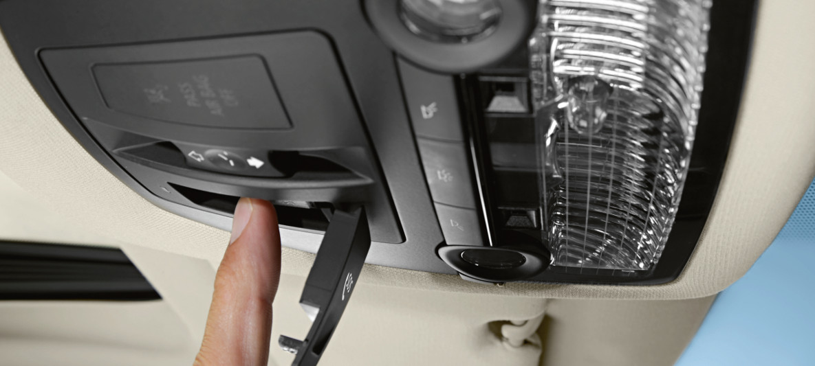 Botão de Chamada de Emergência Inteligente sendo apertado, disponível no teto do veículo BMW Botão de Chamada de Emergência Inteligente sendo apertado, disponível no teto do veículo BMW