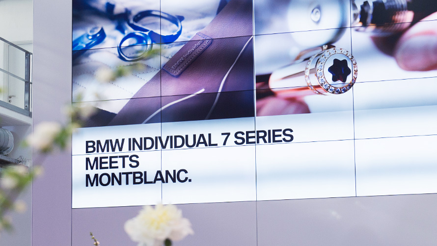 Destaque de enorme tela de projeção durante evento, com dizeres BMW Individual 7 Series Meets Monblanc Destaque de enorme tela de projeção durante evento, com dizeres BMW Individual 7 Series Meets Monblanc