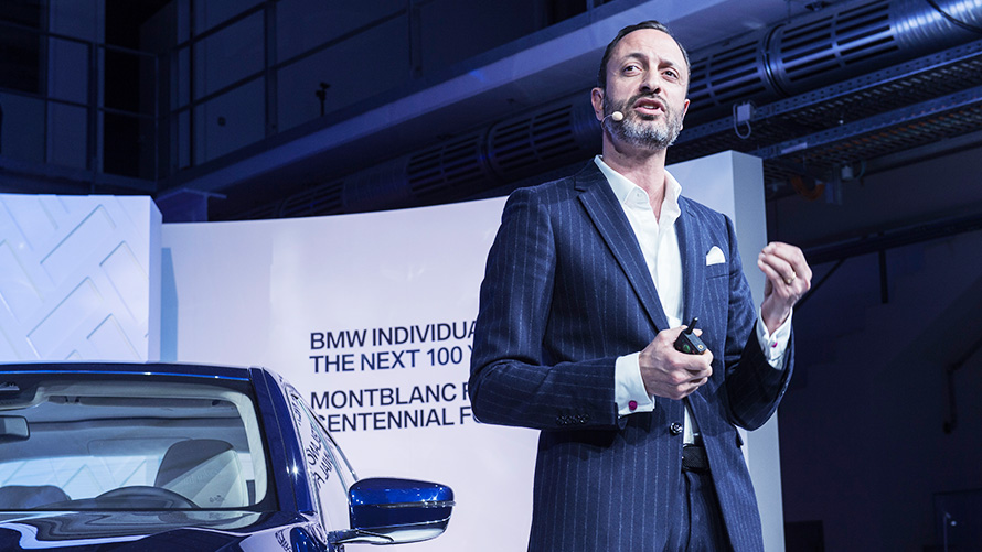 Apresentador falando durante evento sobre BMW Série 7 The Next 100 Years Apresentador falando durante evento sobre BMW Série 7 The Next 100 Years