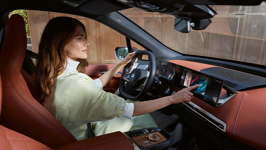 Uma mulher no banco do motorista de um BMW iX, My Modes