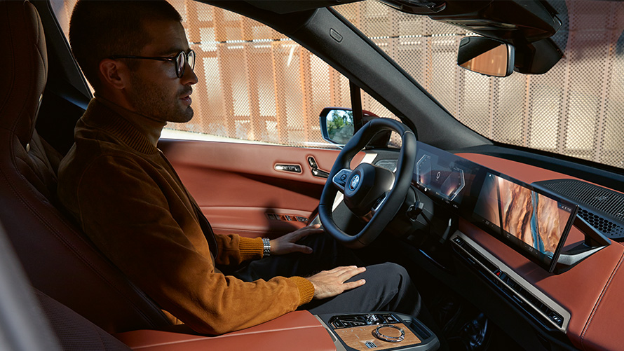 Vista interior com um homem no BMW iX I20. Homem olhando do interior do BMW iX I20 através da janela do passageiro.