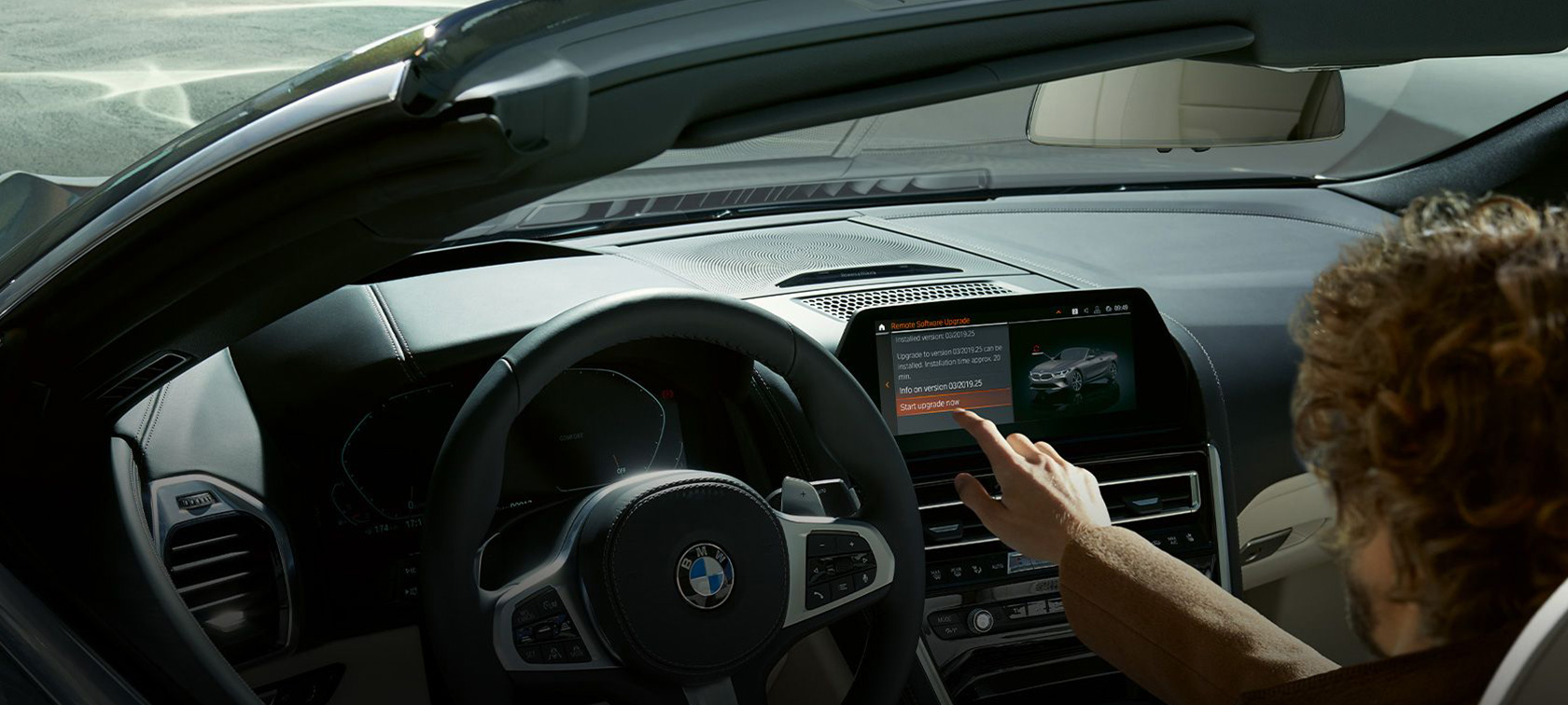 Atualização remota de software BMW Homem sentado no BMW a iniciar a atualização remota de software BMW