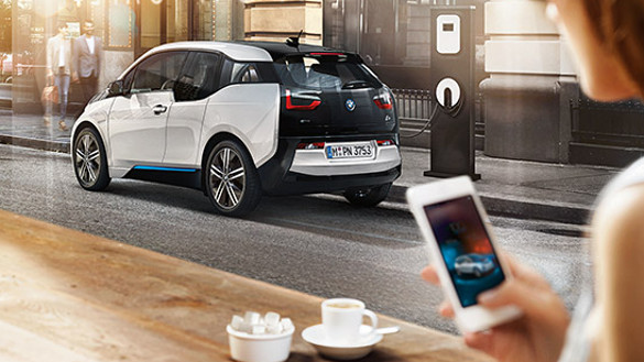 BMW i3 estacionado carregando suas baterias, enquanto proprietária toma um café e acompanha dados do carregamento via seu smartphone BMW i3 estacionado carregando suas baterias, enquanto proprietária toma um café e acompanha dados do carregamento via seu smartphone