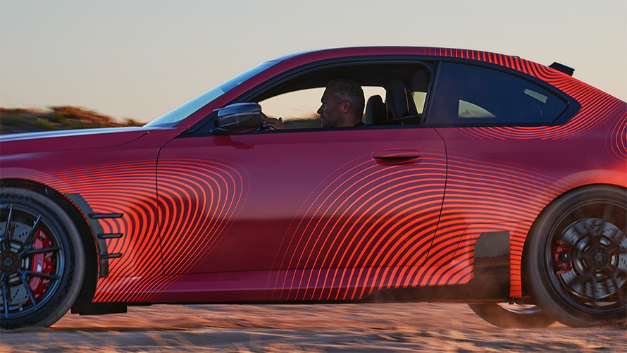 BMW M2 Cupê G87, Peças BMW M Performance, vista lateral 3/4, com o veículo em movimento.