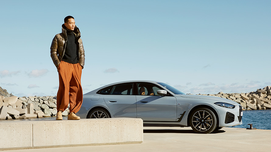 Um BMW em frente a um cenário de verão, com uma modelo BMW Service Inclusive, um BMW em frente a um cenário de verão, com uma modelo