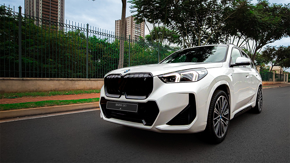 BMW iXi Premium Selection passando em rua de bairro. BMW iXi Premium Selection passando em rua de bairro.