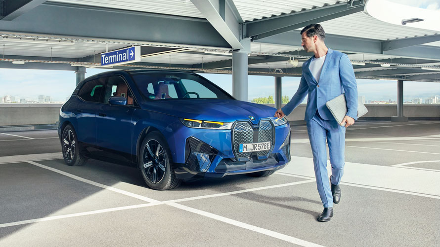 Segurança com Garantia estendida BMW. Motorista caminha após estacionar seu carro BMW com segurança e garantia estendida.