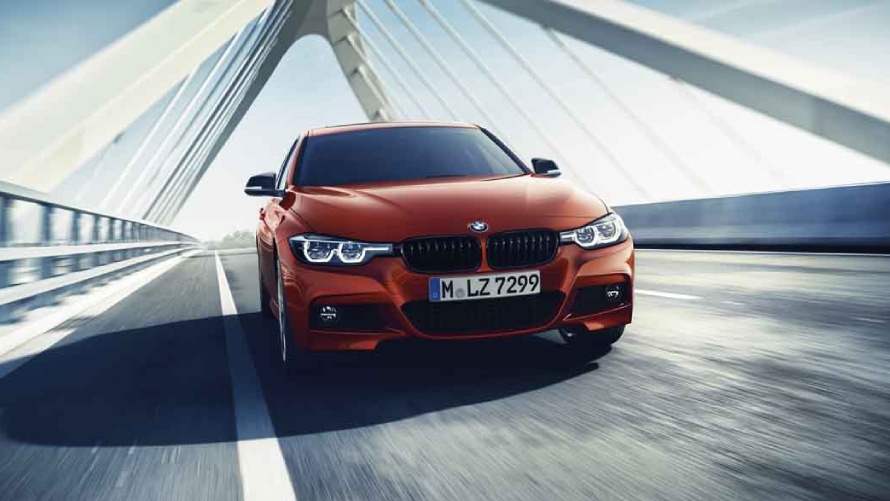 Veículo vermelho BMW Premium Selection com 2 anos de garantia atravessando ponte.